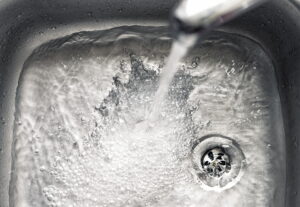 tapwater-flowing-through-faucet-into-sink